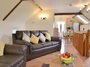 a living room with a leather couch and a table at Pippins in Penybont