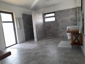 baño con lavabo y aseo y ventana en Jags villa, en Plaine Magnien