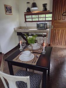 a dining room table with plates and candles on it at Pousada Fazenda Pedra Riscada in Lumiar