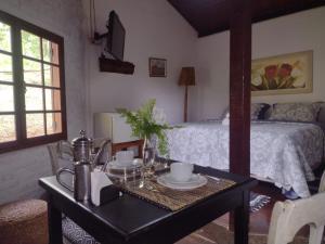 a bedroom with a bed and a table with a table sidx sidx sidx at Pousada Fazenda Pedra Riscada in Lumiar