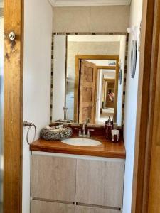 y baño con lavabo y espejo. en Hermosa y comoda casa de campo con vista al valle, en Limache
