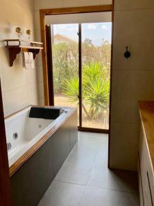 baño con bañera y ventana grande en Hermosa y comoda casa de campo con vista al valle, en Limache