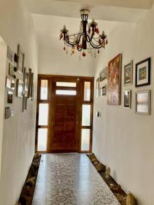 a hallway with a chandelier and a door in a room at Hermosa y comoda casa de campo con vista al valle in Limache