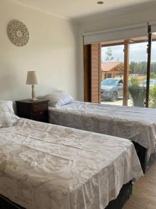 2 camas en un dormitorio con ventana en Hermosa y comoda casa de campo con vista al valle, en Limache