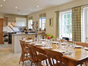 uma cozinha e sala de jantar com uma mesa de madeira e cadeiras em Little Blackhall Lodge em Banchory