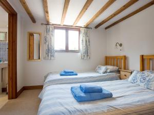 2 camas en una habitación con ventana en Swallows Cottage en Bideford