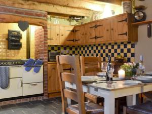 a kitchen with a table with chairs and a stove at The Stables in Whitland