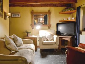 a living room with two couches and a television at The Stables in Whitland