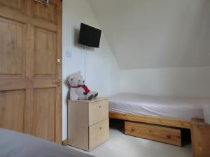 a teddy bear sitting on a dresser in a bedroom at The Den - E5024 in Howell