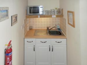 a kitchen with a sink and a microwave at The Den - E5024 in Howell