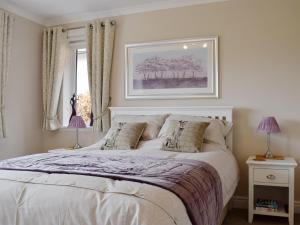 a bedroom with a large white bed with two lamps at Brandelhow in Keswick