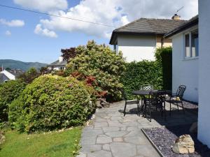 a patio with a table and chairs next to a house at Brandelhow in Keswick