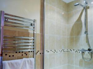 a shower with a glass door in a bathroom at Penrhiw in Llangeitho