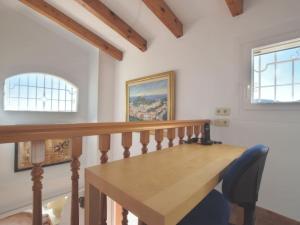 a dining room with a wooden table and two windows at TORRE DON BENITO - Large home, sea views & pool in Begur