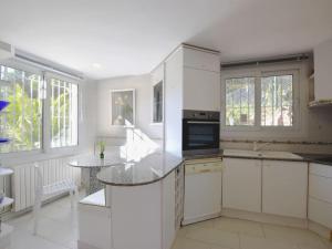 a kitchen with white cabinets and a counter top at TORRE DON BENITO - Large home, sea views & pool in Begur