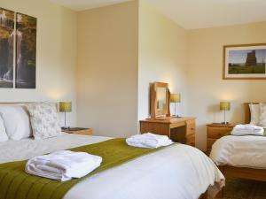 a bedroom with two beds with towels on them at Eithinog in Talybont