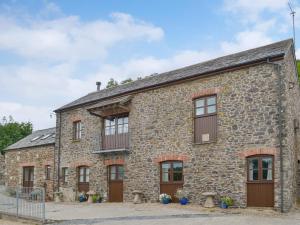 an old stone building with wooden doors and windows at Woods Close -17381 in Kilkhampton