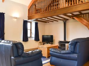 a living room with two leather chairs and a television at Woods Close -17381 in Kilkhampton