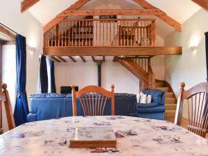 a dining room with a table and chairs and a loft at Woods Close -17381 in Kilkhampton