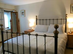 a bedroom with a large bed with two lamps at Woods Close -17381 in Kilkhampton