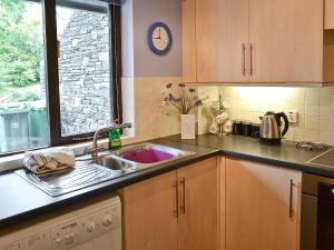 a kitchen with a sink and a window at Long Mynd in Ambleside