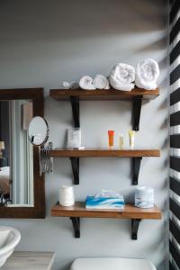 a bathroom with wooden shelves with towels and a mirror at Auberge Beausejour in Amqui