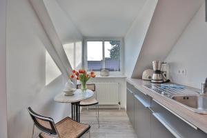 une cuisine avec une table et un vase de fleurs. dans l'établissement Haus am Seehof 6 Seehof, à Sierksdorf