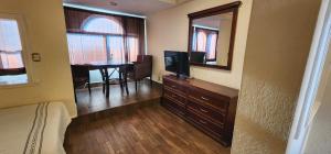 1 dormitorio con 1 cama, TV y mesa en Hotel y Restaurant Puesta del Sol en Ocotlán