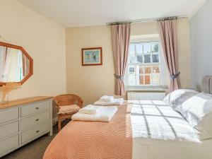 a bedroom with a bed and a dresser and a window at Dunster Castle Hill View - Uk13179 in Dunster