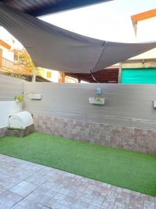 patio ze ścianą ze stołem i trawą w obiekcie Demetris apartment w mieście Meneou