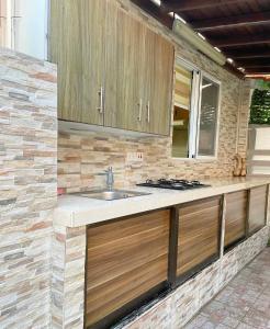 uma cozinha com armários de madeira e um lavatório em Demetris apartment em Meneou