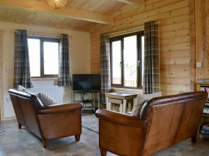 a living room with two chairs and a television at Callow Lodge in Meadowtown