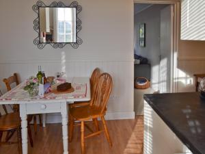 a kitchen with a table with chairs and a mirror at The Broomes in Whitstable