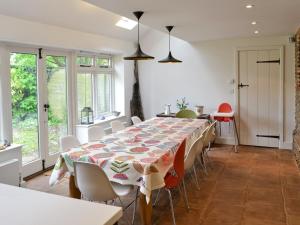 Chapel Cottage في Sharrington: غرفة طعام مع طاولة وكراسي طويلة