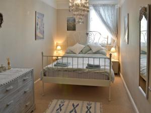 a bedroom with a bed with a chandelier at The Broomes in Whitstable