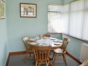 comedor con mesa de madera y sillas en Copper View, en Coniston