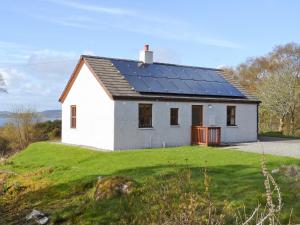 a white house with solar panels on the roof at Moy in Taynish