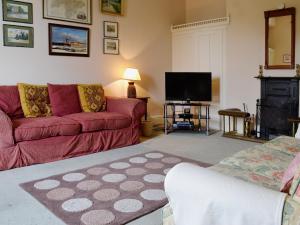 a living room with a red couch and a flat screen tv at Maes Gwyn - Hw7644 in Llandudno
