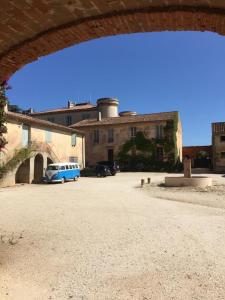 a building with a blue car parked in a parking lot at Les vendangeurs a 800 m de la mer in Bormes-les-Mimosas