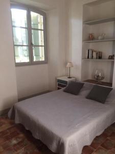 a bedroom with a large bed and a window at Les vendangeurs a 800 m de la mer in Bormes-les-Mimosas