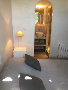 a bedroom with a bed and a bathroom with a sink at Les vendangeurs a 800 m de la mer in Bormes-les-Mimosas +8 photos