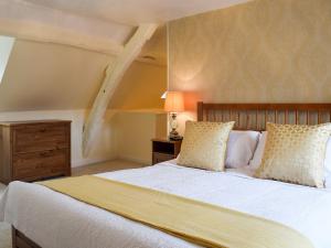 a bedroom with a large white bed with a wooden headboard at Honeyz Hideaway in Whitby