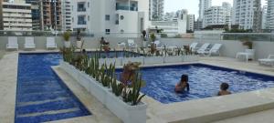 dos niños jugando en una piscina en un edificio en Hermoso Apartamento en Bocagrande-Cartagena, en Cartagena de Indias