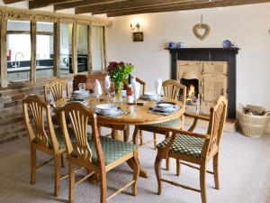 a dining room with a table and chairs and a fireplace at Shrubberies Cottage - Dc5472 in Skinningrove
