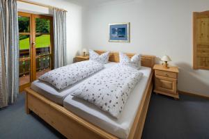 Un dormitorio con una cama con almohadas blancas y una ventana en Ferienwohnungen Freidinglehen en Marktschellenberg