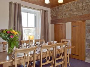 a dining room with a table and chairs and a window at The Sycamores in Clynderwen