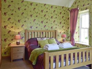 a bedroom with a bed with two night stands and two lamps at The Sycamores in Clynderwen