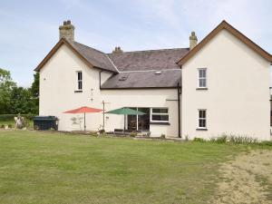 a white house with two umbrellas in a yard at The Sycamores in Clynderwen