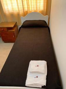 Una cama con dos toallas blancas encima. en La casita en San Rafael