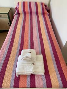 un par de toallas sentadas en una cama en La casita en San Rafael